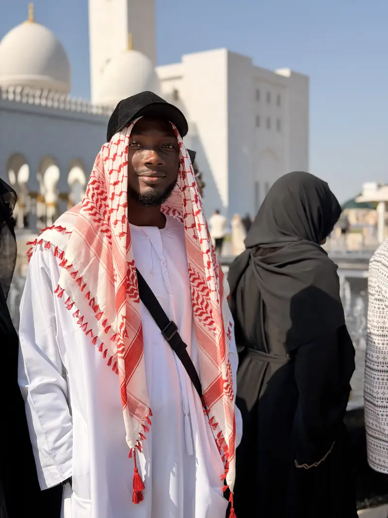 A traveller wearing a white kandura and red-and-white keffiyeh at the Grand Mosque