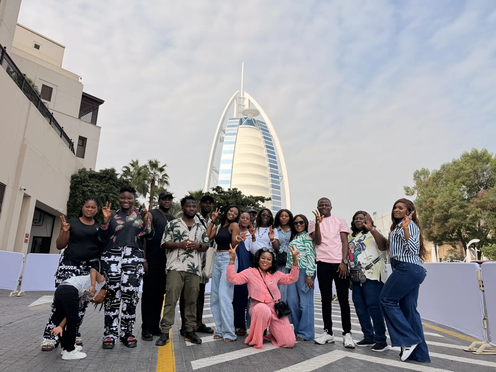 A Myma Travels group posing together in front of the Burj Al Arab in Dubai