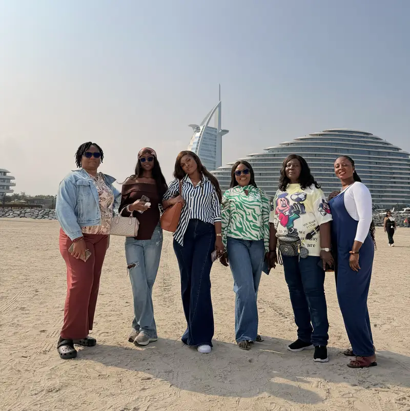 Six women from the group posing on the beach near the Burj Al Arab