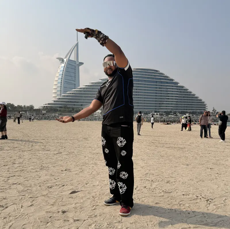 A traveller playfully posing as if holding the Burj Al Arab between his hands