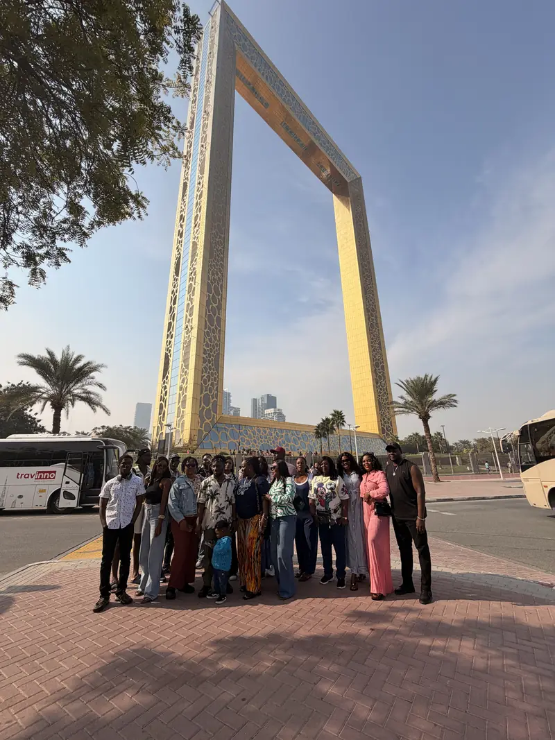 The Myma Travels group standing beneath the Dubai Frame