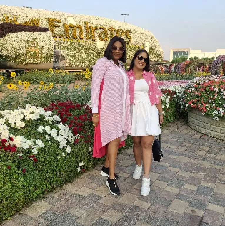 Two travellers in pink standing among flower beds at Dubai Miracle Garden