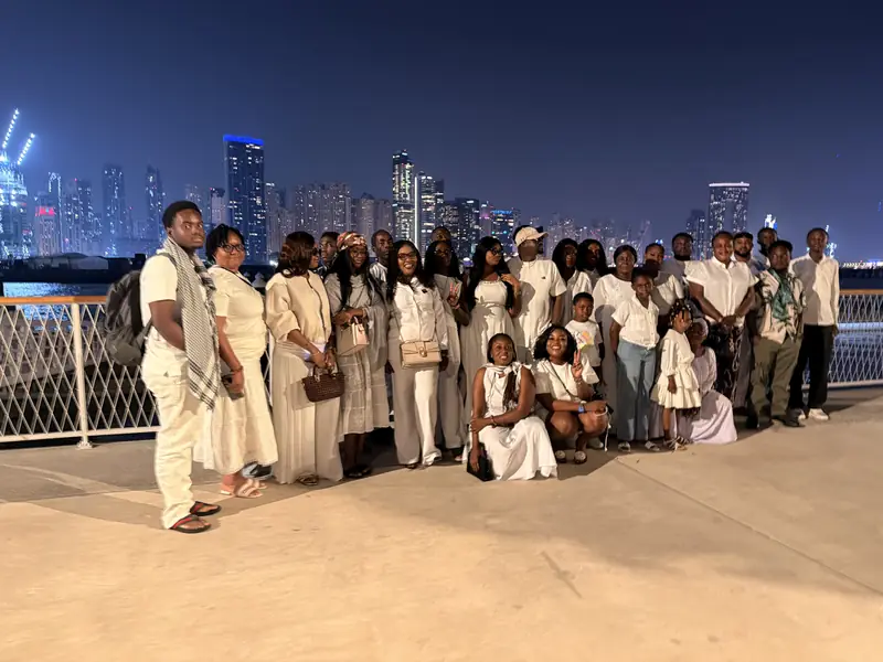 Another view of the group in white with the Dubai skyline at night