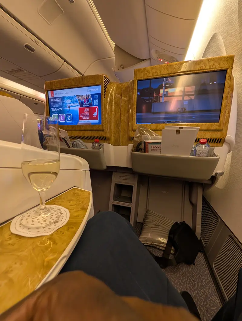 A glass of champagne in a premium cabin with seatback screens