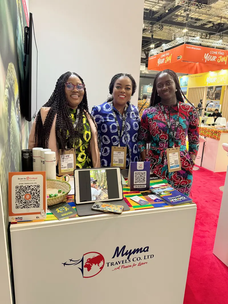 Three members of the Myma Travels team at the Myma stand in an exhibition hall